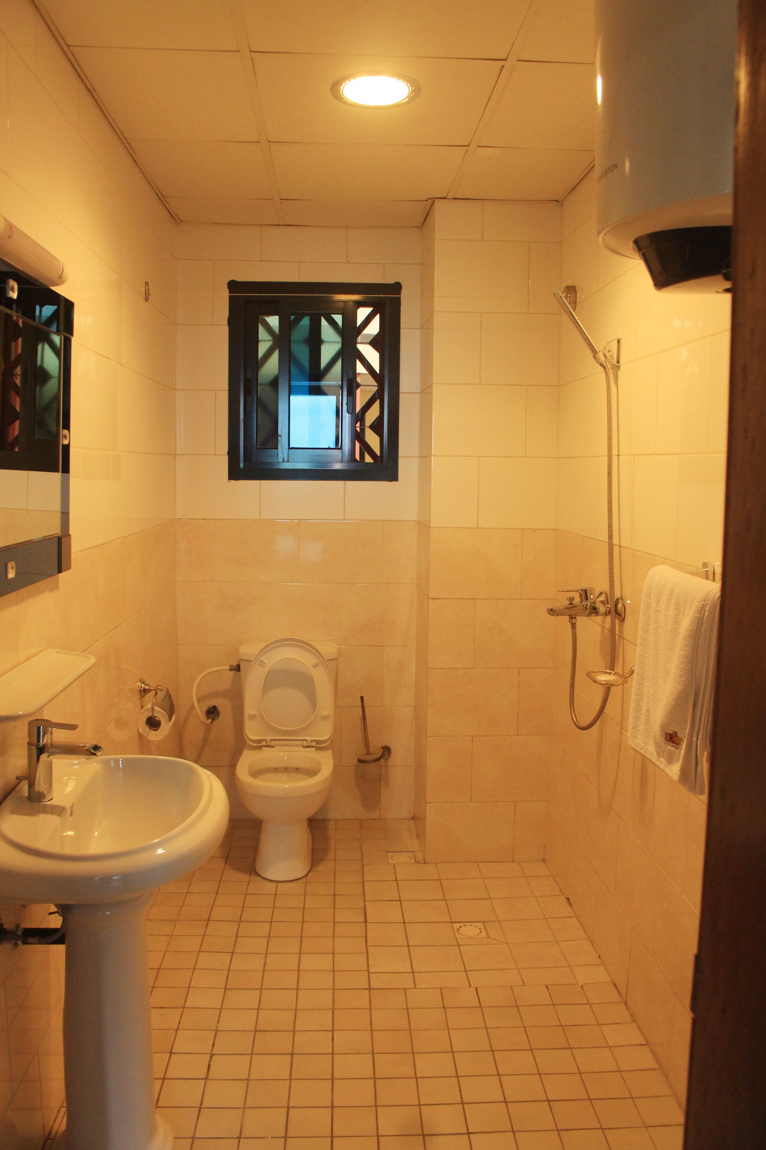 A bathroom with a toilet, sink, and shower.
