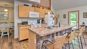 A kitchen with wooden cabinets, a granite countertop, a built-in stove, and a refrigerator. - Deck, Hot Tub & Game Room: Lake Harmony Home (Lake Harmony)