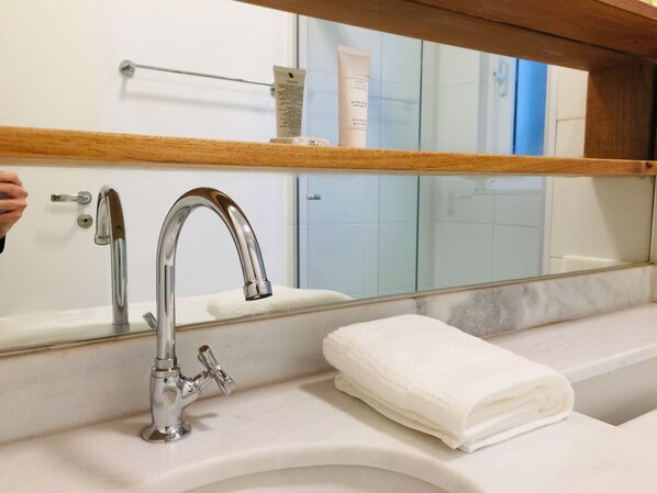 Une salle de bain avec un lavabo moderne, un miroir et une serviette.