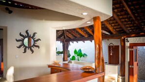 Un comptoir en bois orné d’un soleil décoratif sur le mur, un mur en pierre et une porte donnant sur une pièce avec vue.