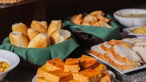 En buffet med forskelligt brød og en tallerken med ternede madvarer.