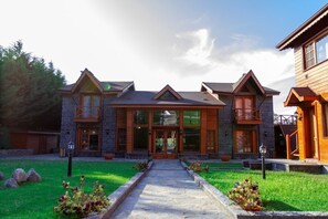 A stone building with a central entrance, large windows, and a stone pathway leading to the door. - The Swanpark Hotel (Sile)