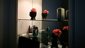Una vitrina de vidrio con objetos decorativos y un espejo que refleja la habitación.