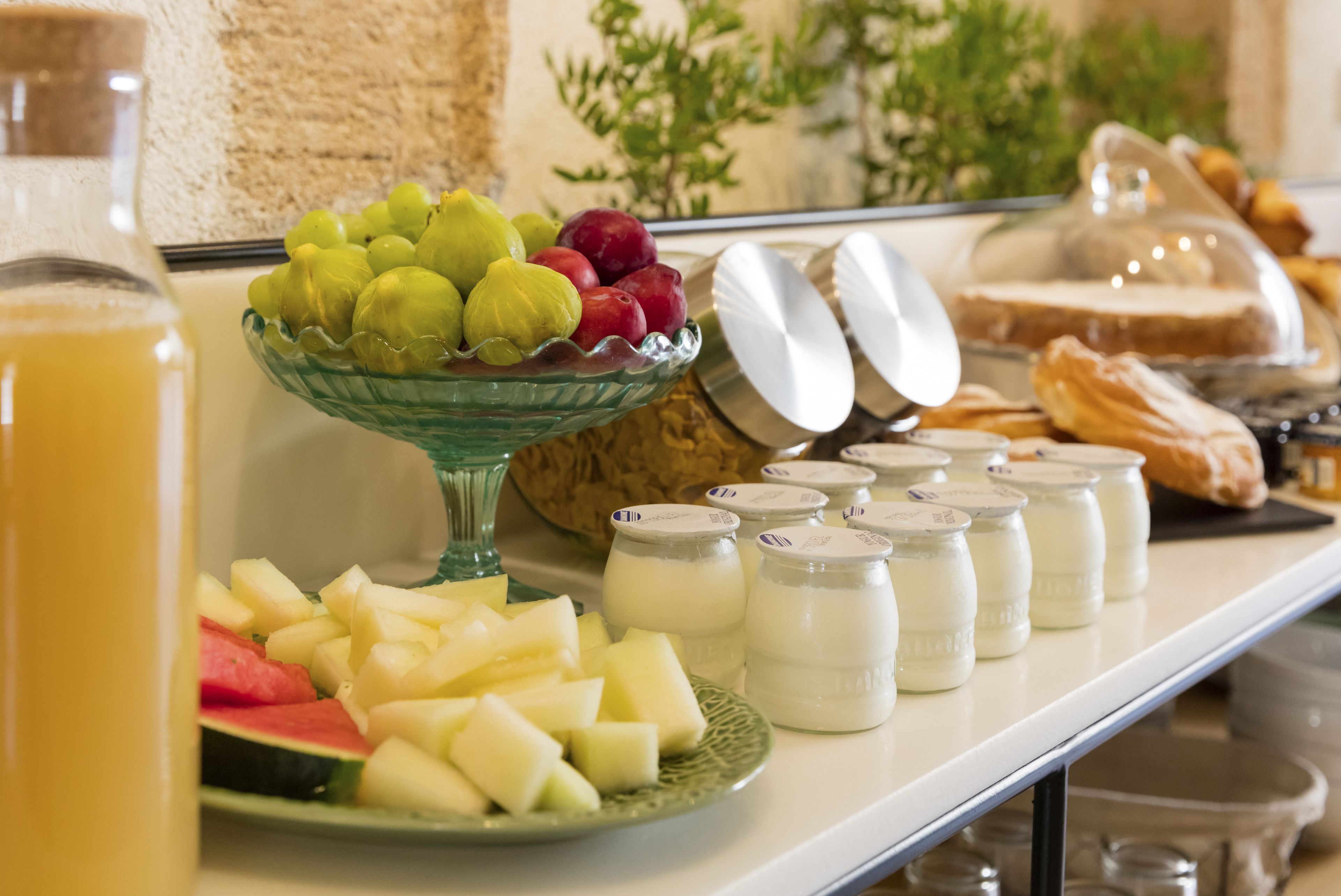 Un tavolo del buffet con diverse pietanze, tra cui frutta, dolci e latticini.