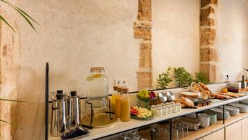A buffet setup with various food items, beverages, and utensils.