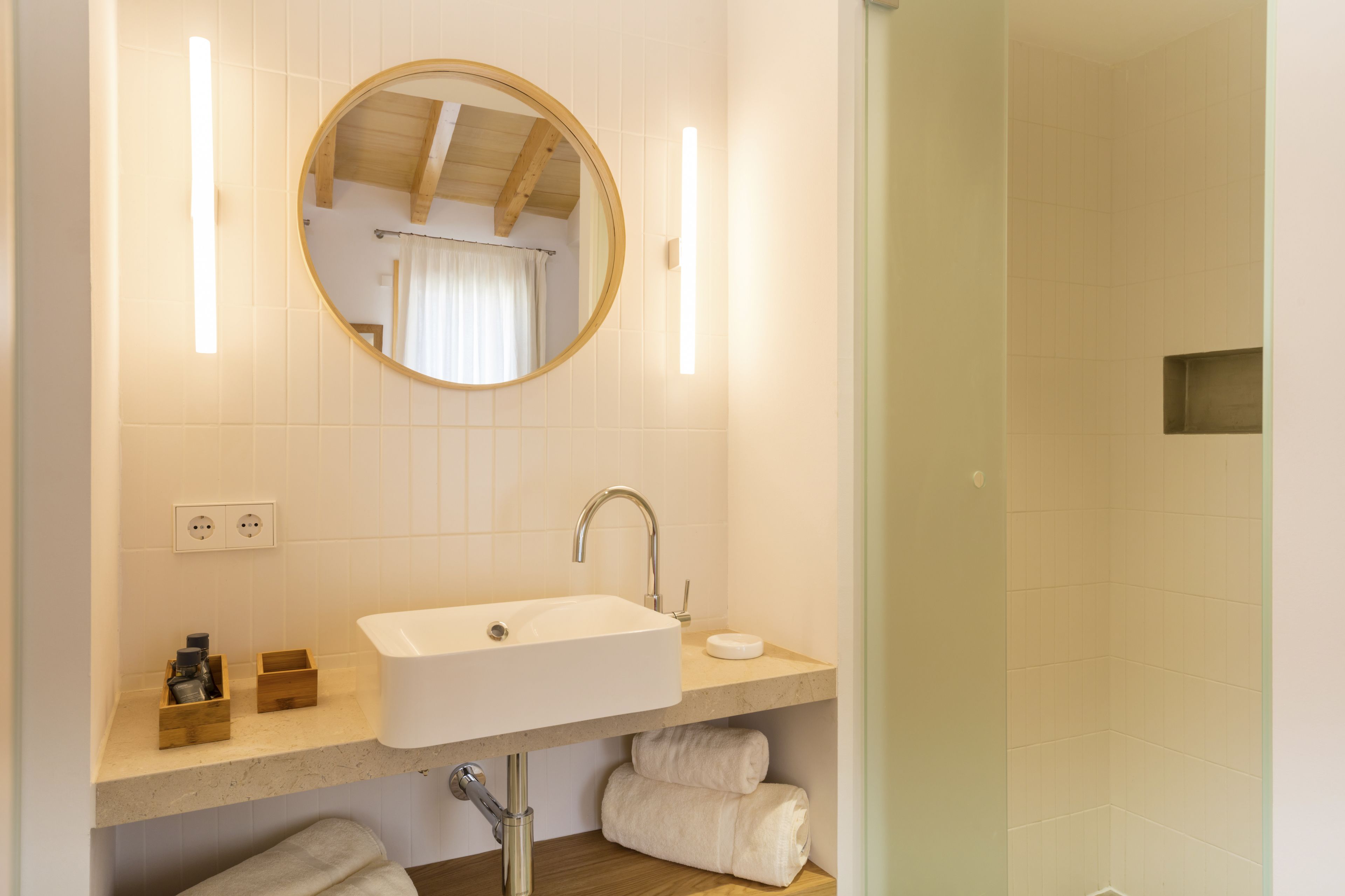 A bathroom with a sink, mirror, and towel rack.