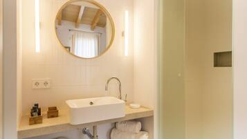 A bathroom with a sink, mirror, and towel rack.