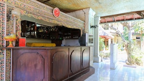A bar area with a clock, tiled floor, and decorative wall. - Sari Bali Resort (Kuta)