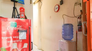 A vending machine with Coca-Cola and GrabFood logos, a water dispenser, and a fire extinguisher. - Techno Inn (Makassar)