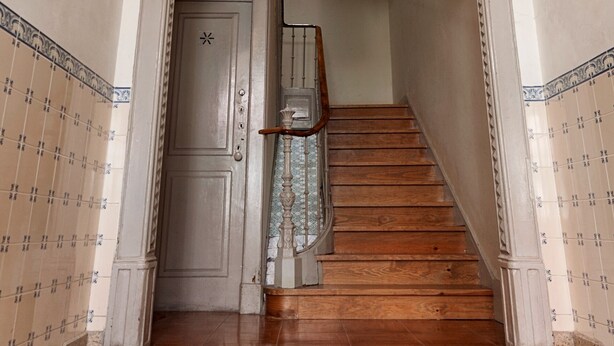 Un escalier avec une rampe en bois et une porte en haut.