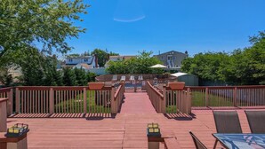 A wooden deck with a pool, surrounded by a fence and trees. - Great Family Times In this lovely Cape with Resort style backyard (Massapequa)