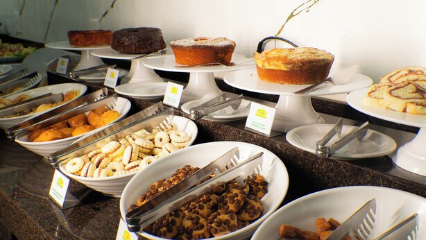 Un bufé con diversas opciones de panadería y postres.