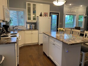 Enjoy cooking in this well-equipped kitchen with a central island, sink, and ample counter space.