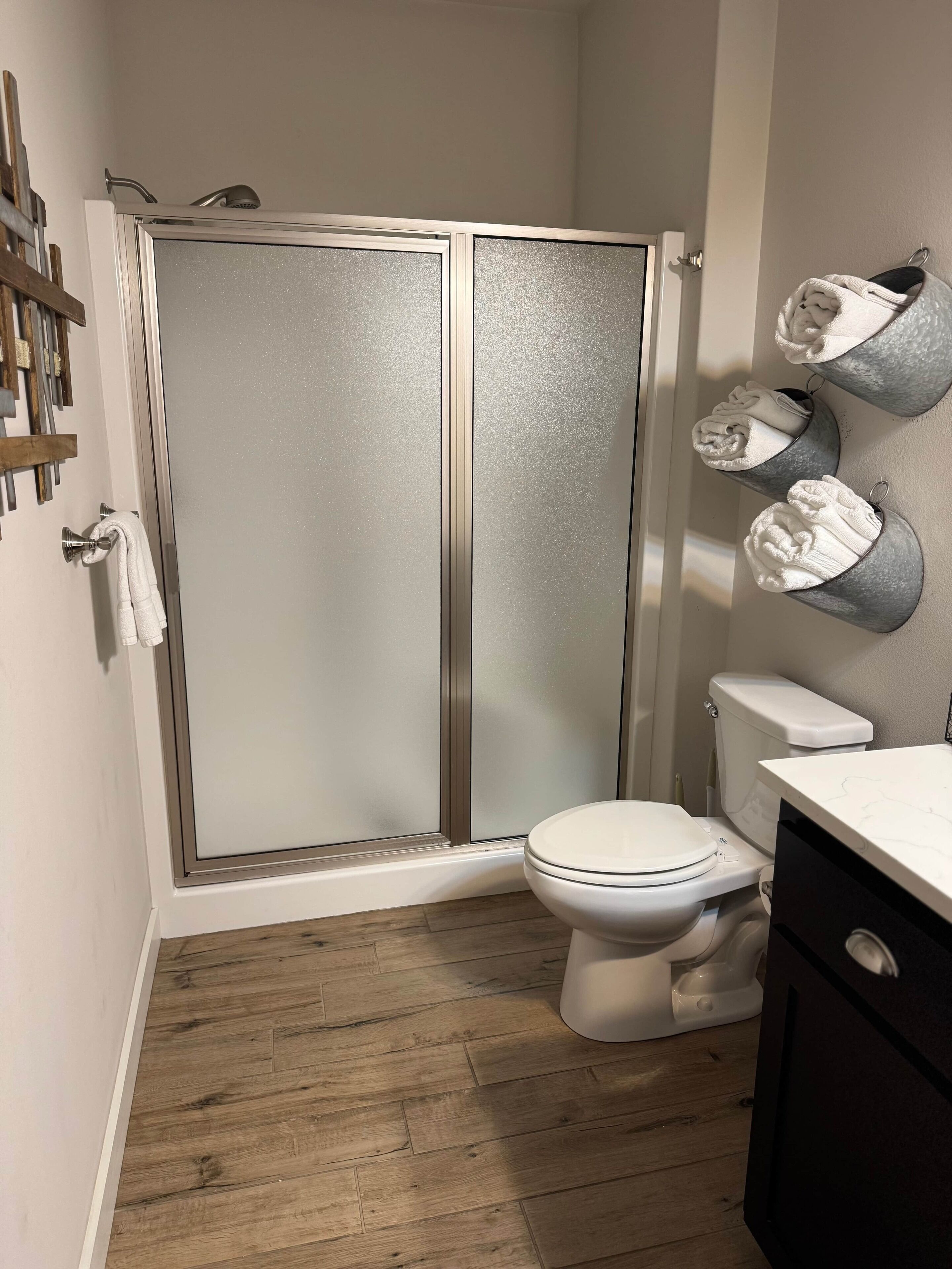 Une salle de bain avec une douche, des toilettes et des porte-serviettes.
