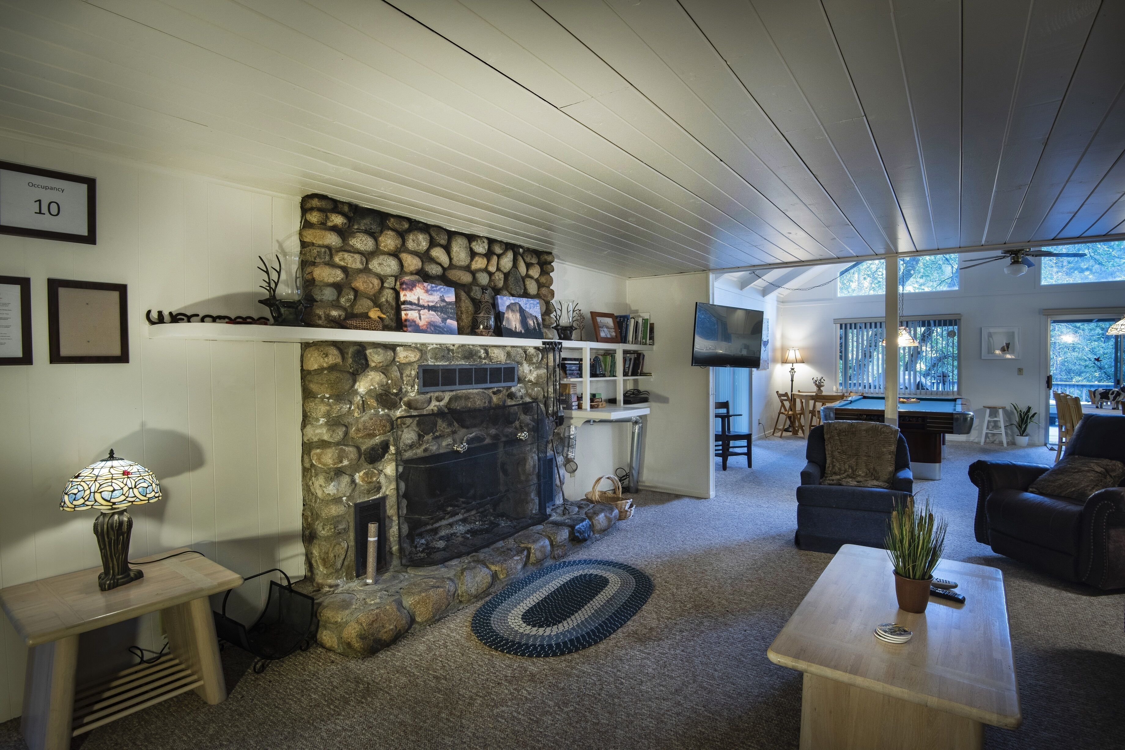 A cozy living room with a stone fireplace, a television, and comfortable seating.