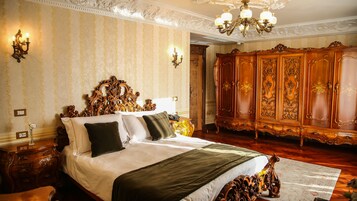 Un dormitorio lujoso con una cama ornamentada, un amplio armario de madera y elegantes apliques.