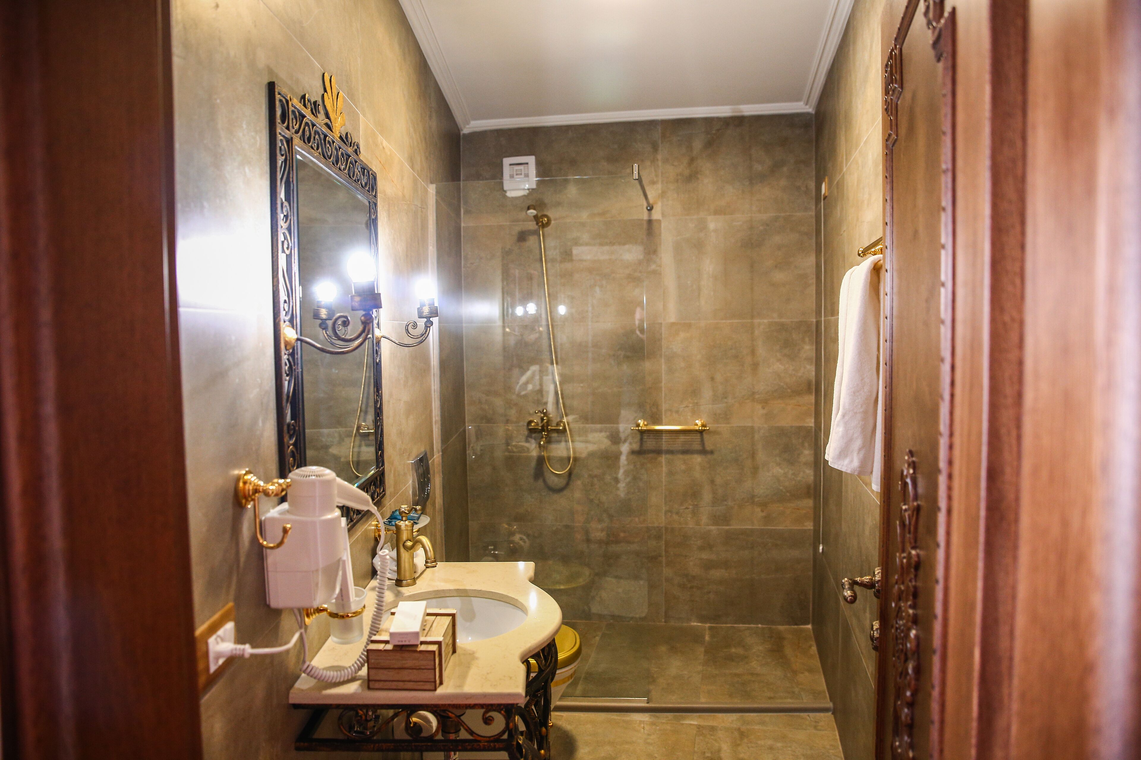 A bathroom with a vanity, mirror, and shower.