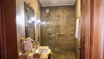 A bathroom with a vanity, mirror, and shower.