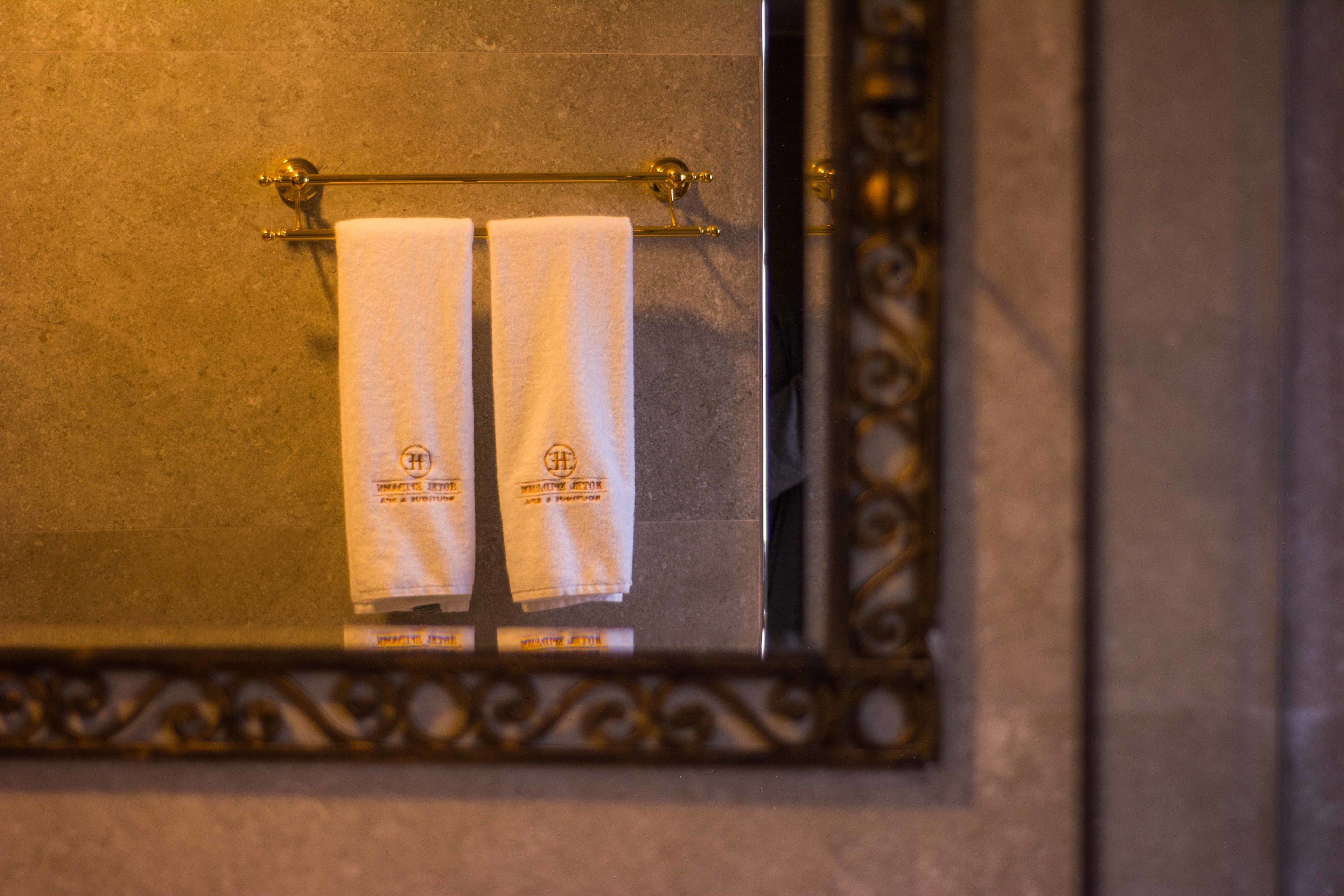 A bathroom with a towel rack holding two white towels.