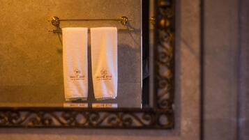 A bathroom with a towel rack holding two white towels.