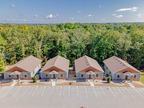 A row of three-story buildings with a parking lot in front.