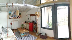 L’intérieur chaleureux d’un chalet, avec un revêtement en bois, une cheminée et une grande fenêtre.