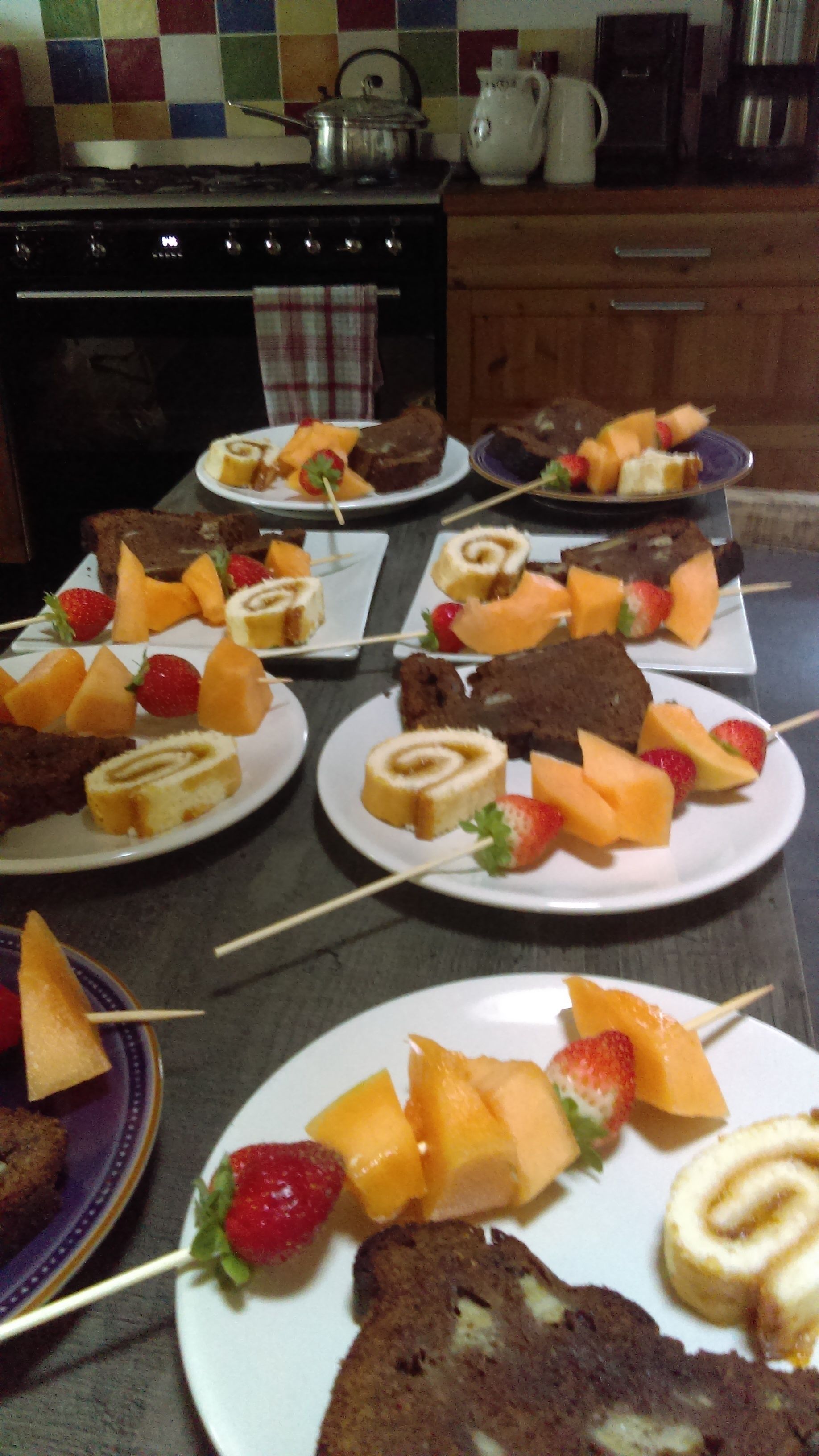 Un piano di lavoro in cucina con diversi piatti di frutta e dolci.