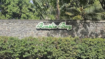 Eine Steinmauer mit einem Schild, auf dem 'Rosalie Bay' steht.