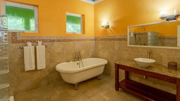 A bathroom with a freestanding bathtub, a vanity with a sink, and a mirror above the sink.
