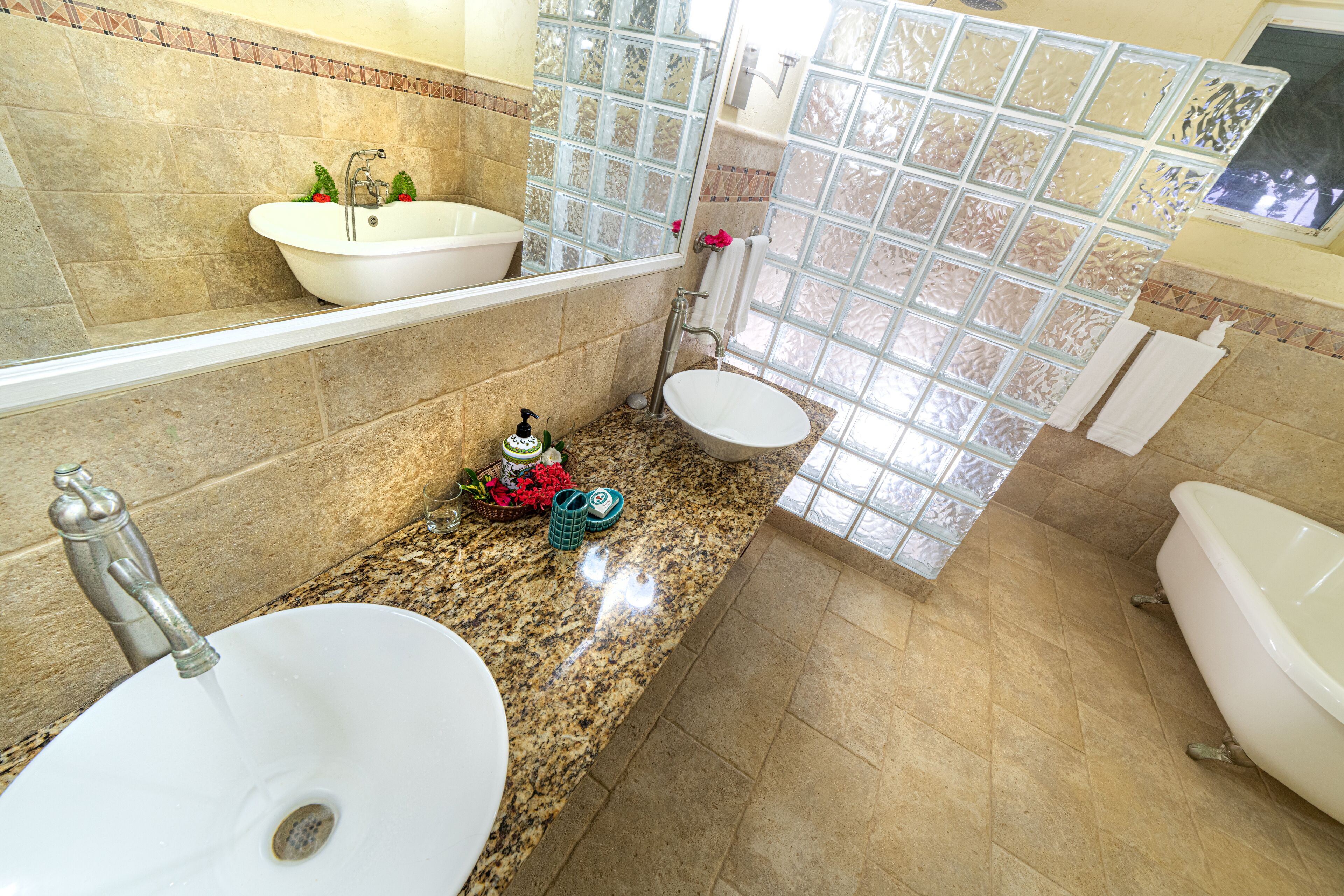 A bathroom with two sinks, a bathtub, and a large window.