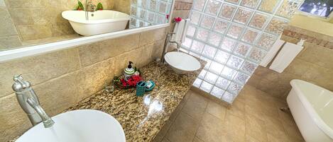 A bathroom with two sinks, a bathtub, and a large window.