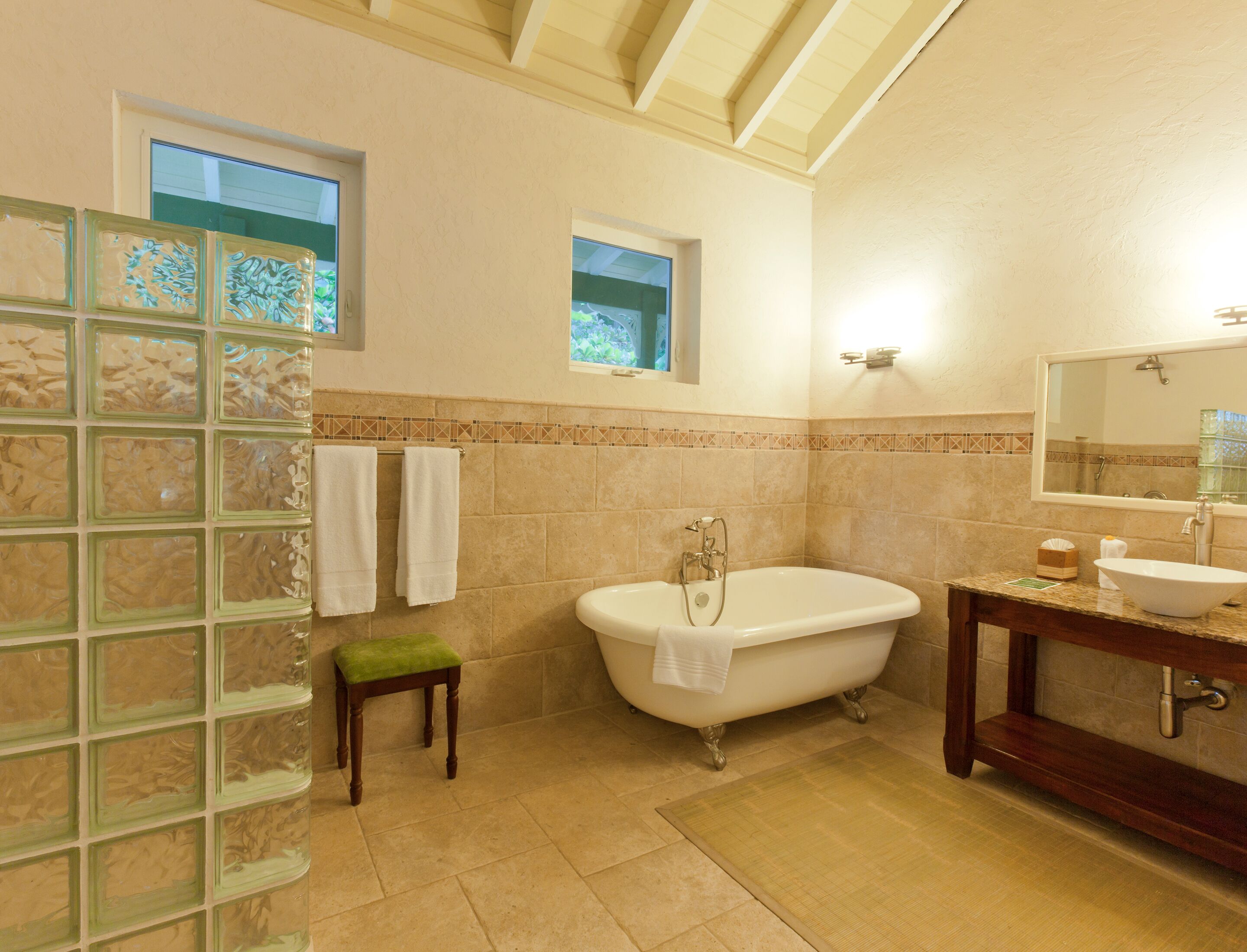 Une salle de bain avec une baignoire, un meuble-lavabo et une fenêtre.