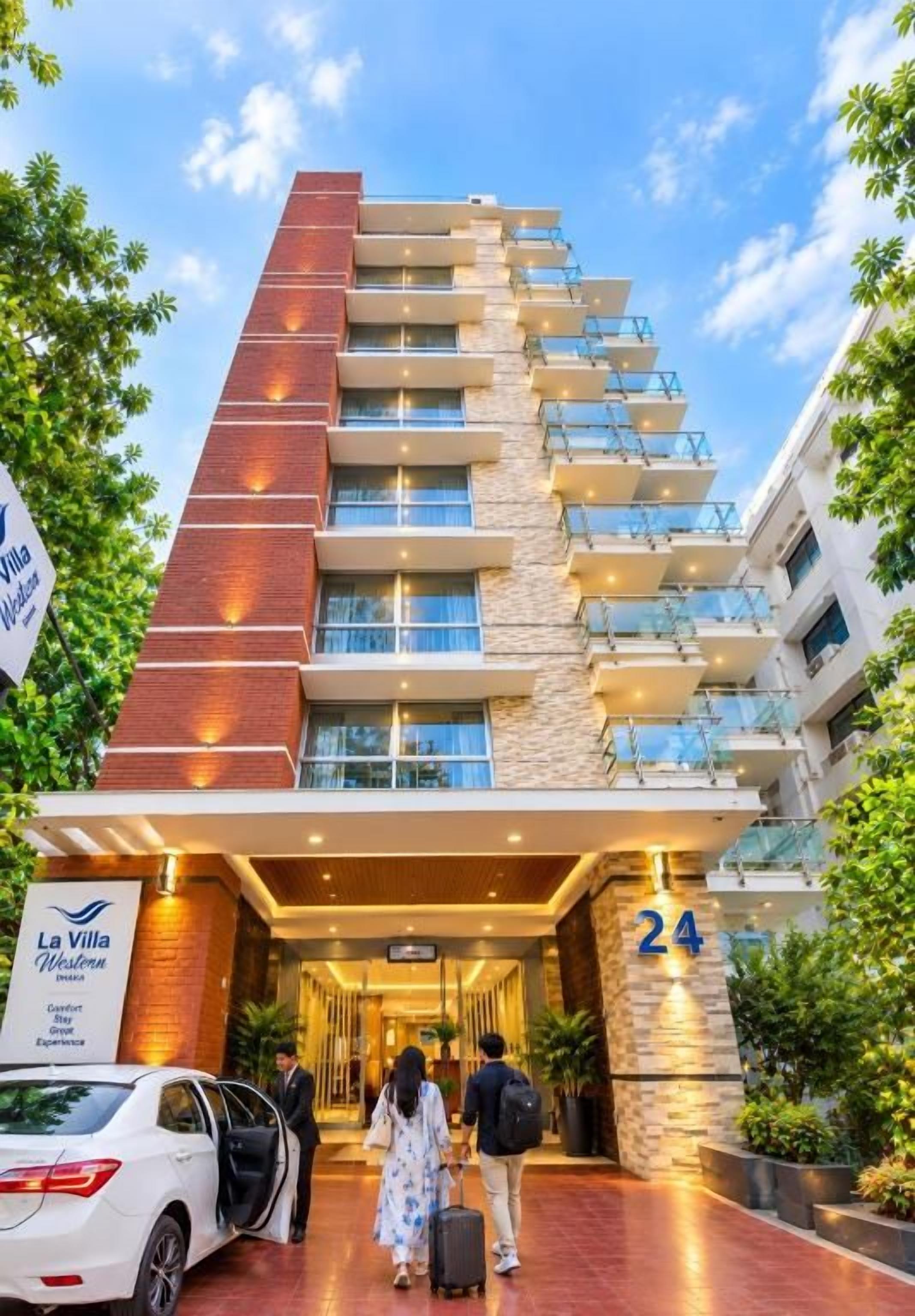 Een hotelentree met een modern ontwerp, met het zichtbare nummer '24' dat het adres van het gebouw aangeeft, en een bord met de tekst 'La Villa Hotel'.