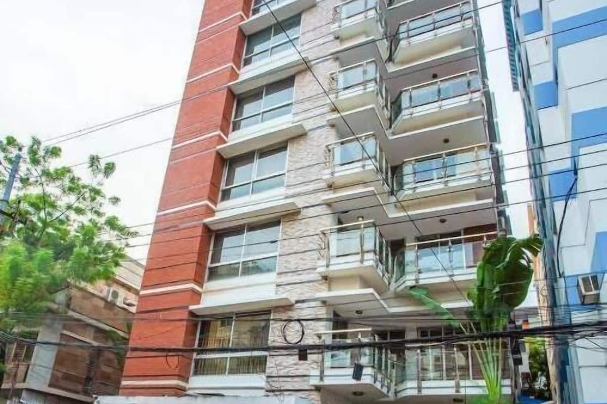 A multi-story building with a red facade and balconies.