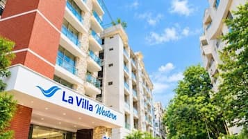 Un hotel de varios pisos llamado 'La Villa Western' con una entrada destacada, número 24, y un cielo despejado.