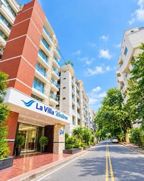 A multi-story hotel named 'La Villa Western' with a prominent entrance, numbered 24, and a clear sky above. - Hotel La Villa Western (Dhaka)