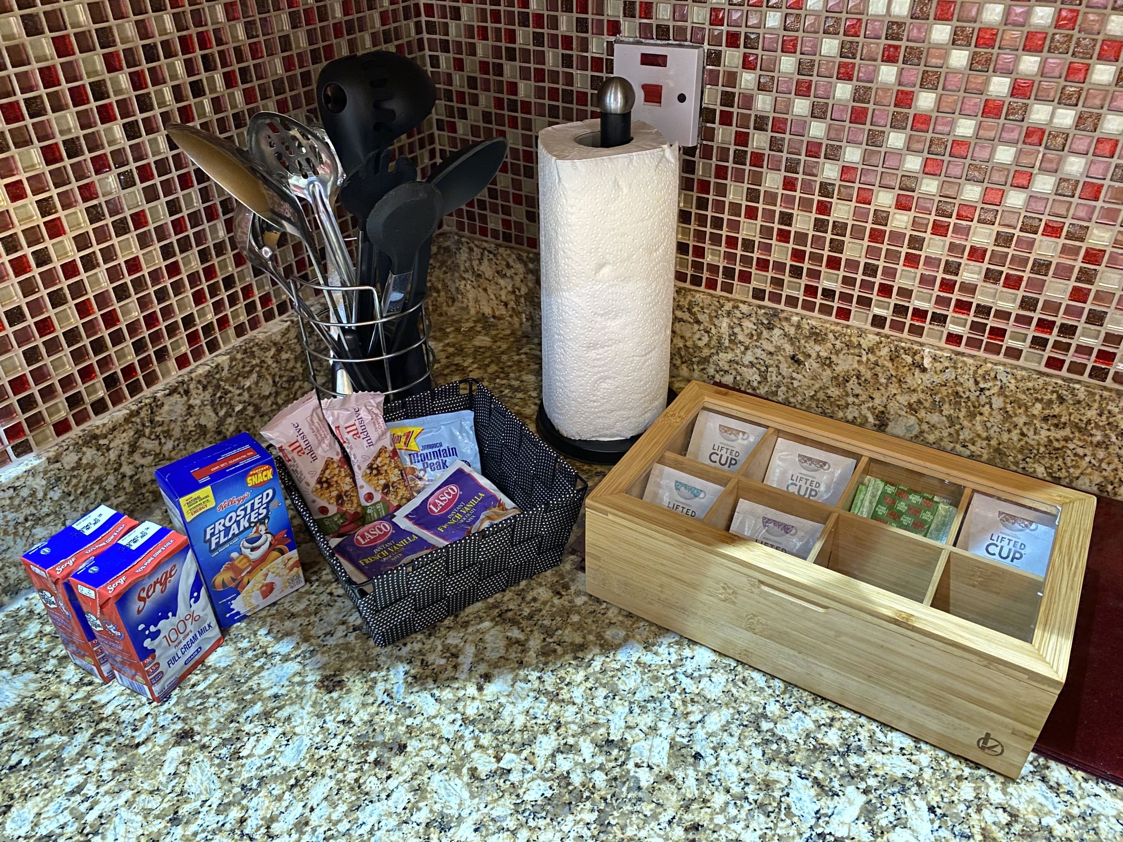 A kitchen counter with various food items, a paper towel holder, and a spice rack.