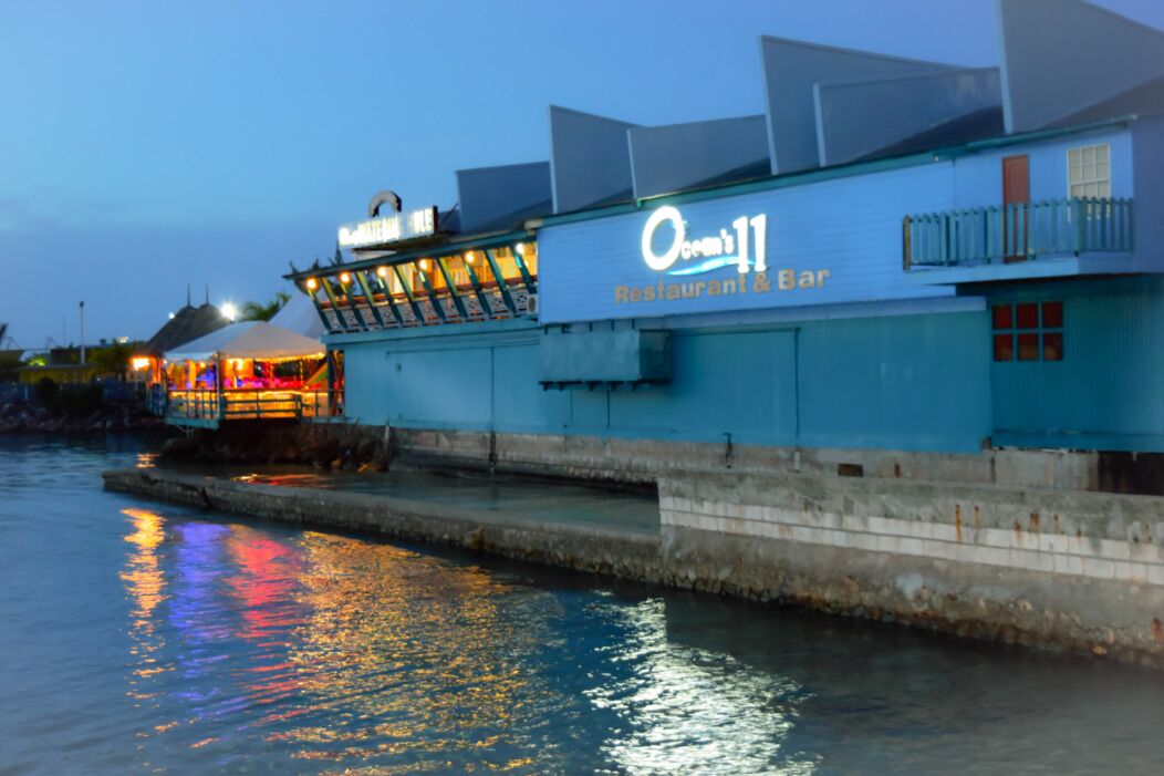A waterfront building with a sign reading "Ocean 11 Restaurant & Bar."