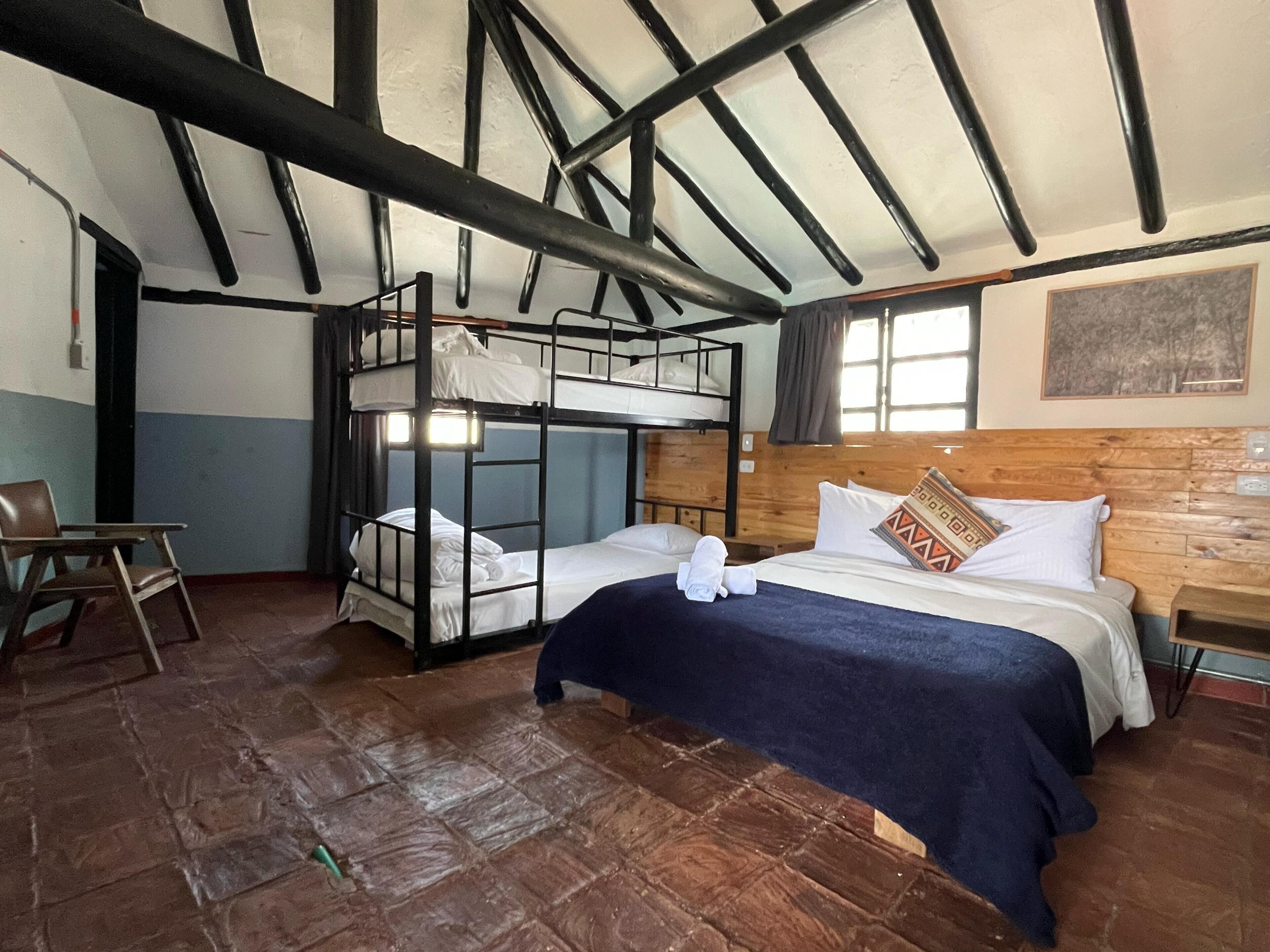 A room with bunk beds, a desk, and a chair.
