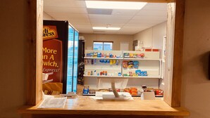 A store interior with wooden counters, shelves stocked with various products, and a visible checkout area. - Target Hospitality-Odessa West Lodge (Notrees)