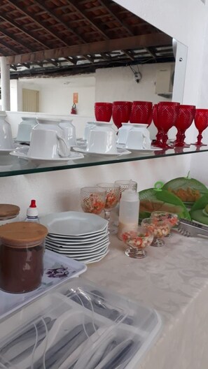 A breakfast buffet setup with various dishes and utensils. - Pousada Executiva (Teresina)
