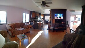 A spacious living room with a sofa, a coffee table, and a television.
