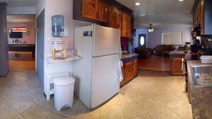 A kitchen with a refrigerator, sink, and a water dispenser.