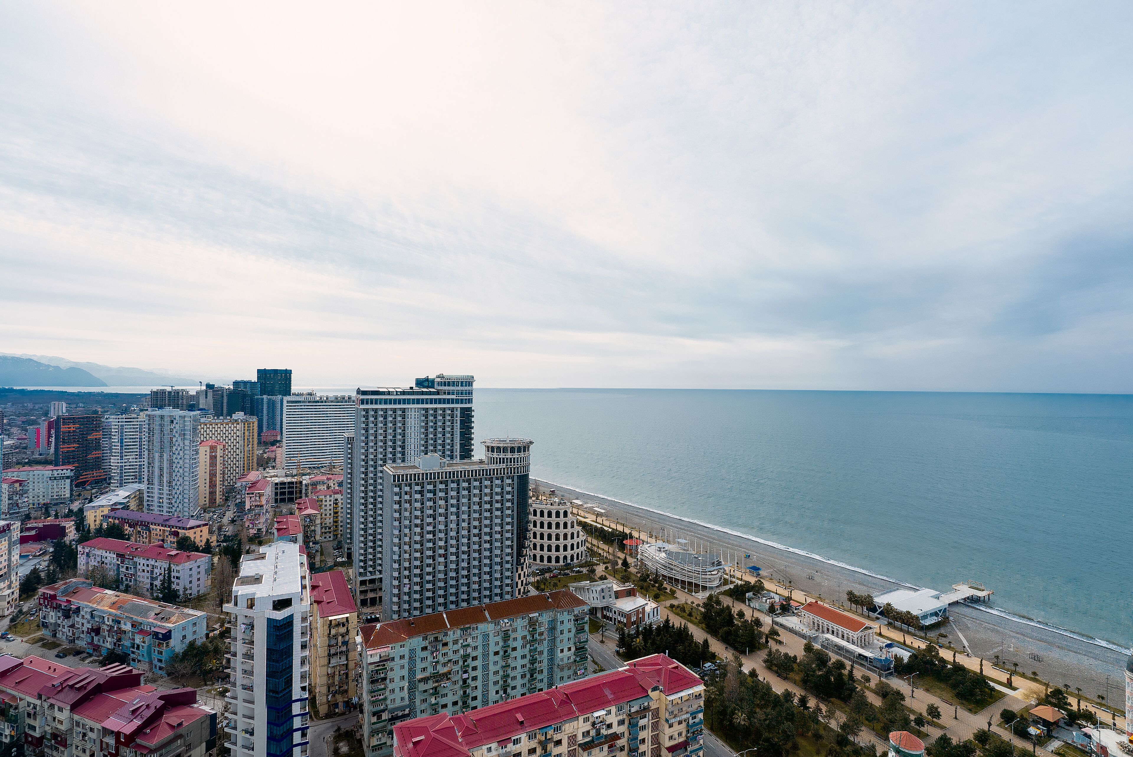 A coastal cityscape with high-rise buildings and a beach.