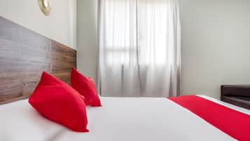 Habitación cuádruple estándar | Tabla de planchar con plancha y ropa de cama