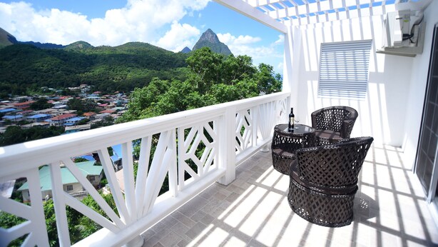 A balcony with wicker furniture, a white railing, and a view of a mountainous landscape. - *Sugarmon Villas* Mout Gimmie Suite with amazingPergola Balcony View! (Soufriere)