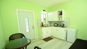 A compact kitchen with white cabinets, a microwave, a coffee maker, and a small refrigerator. - *Sugarmon Villas* Mout Gimmie Suite with amazingPergola Balcony View! (Soufriere)