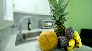 A kitchen counter with a fruit bowl containing a pineapple, a mango, and bananas. - *Sugarmon Villas* Mout Gimmie Suite with amazingPergola Balcony View! (Soufriere)