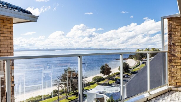 A balcony with a view of a beach and the sea. - Kiah 12, 53 Victoria Pde - Panoramic water views, Wifi and Air Con (Nelson Bay)