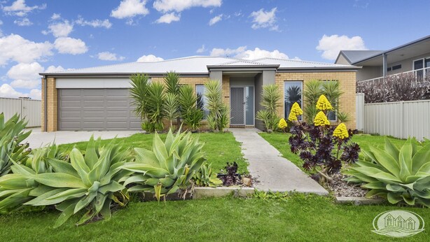 A modern two-story house with a garage, a well-maintained lawn, and a variety of plants. - Modern home close to CBD (Portland North)